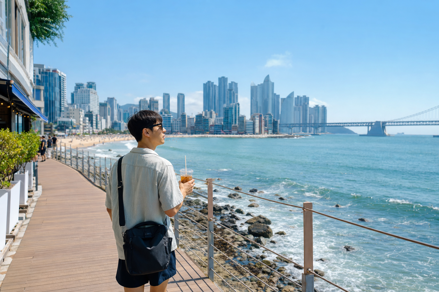 부산 해변 산책길을 걷는 여름 워케이션 여행자
